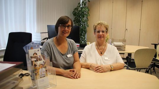 Die Kundenberaterinnen Doreen Gähl und Marion Knoll sitzen am Beratungstisch in einem Büro